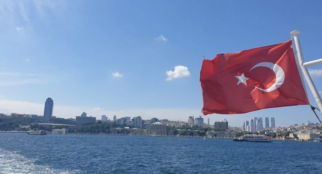 View of Dolmabahce from the Bosphorus with a Turkish flag