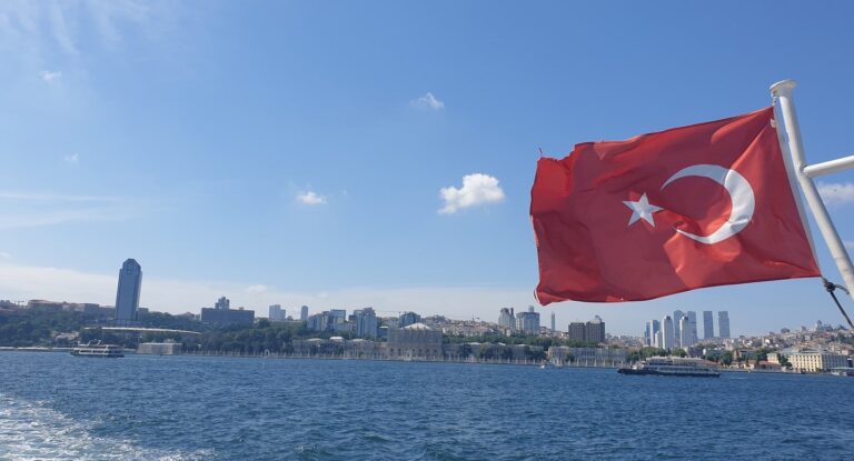 View of Dolmabahce from the Bosphorus with a Turkish flag