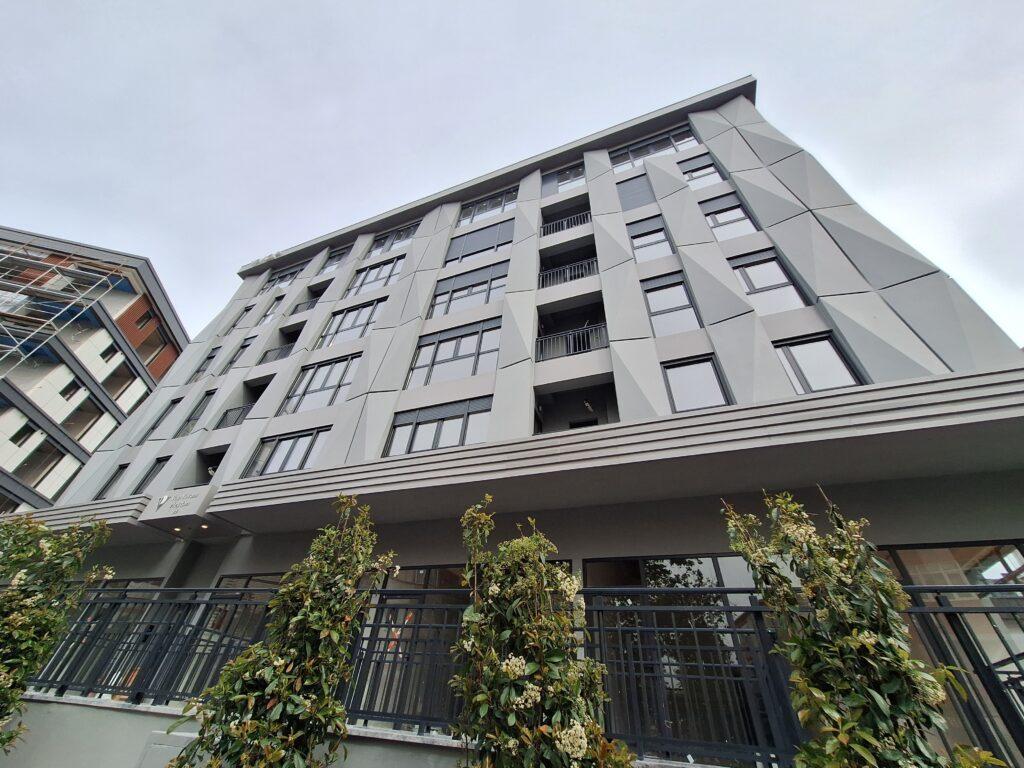 Apartment building in Besitkas - exterior view showing store front and six storey building