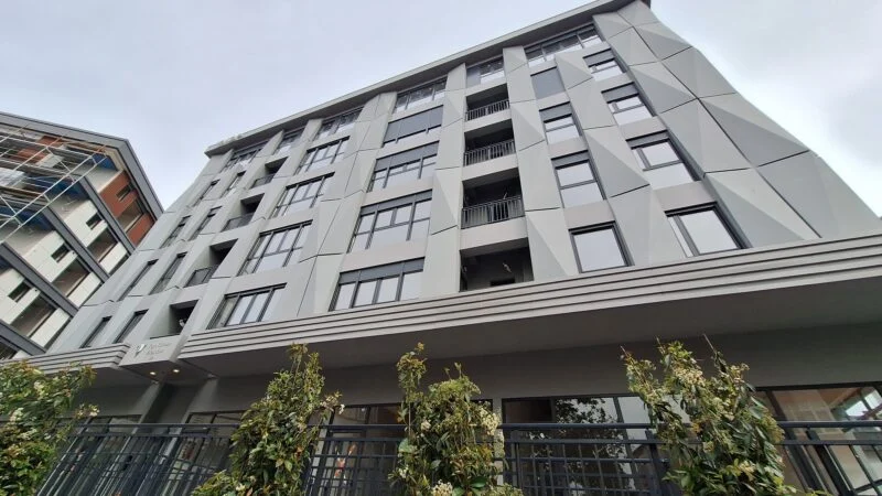 Apartment building in Besitkas - exterior view showing store front and six storey building