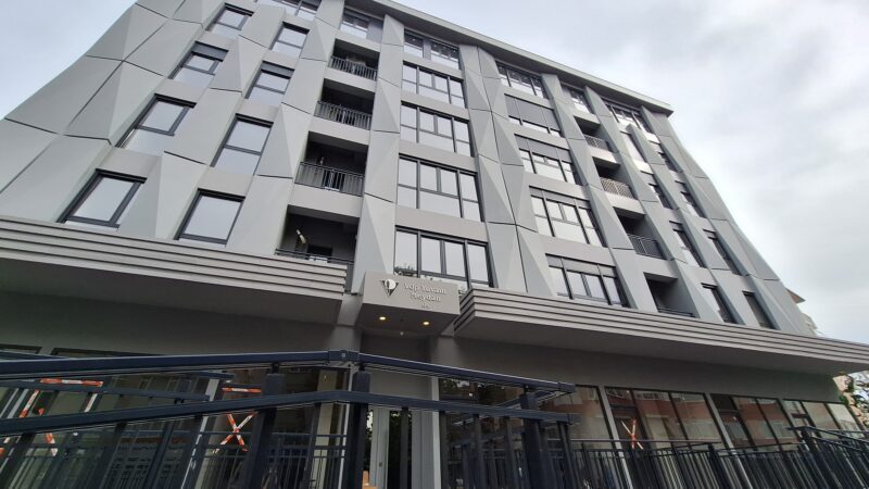 Apartment building in Besitkas - exterior view showing store front and six storey building
