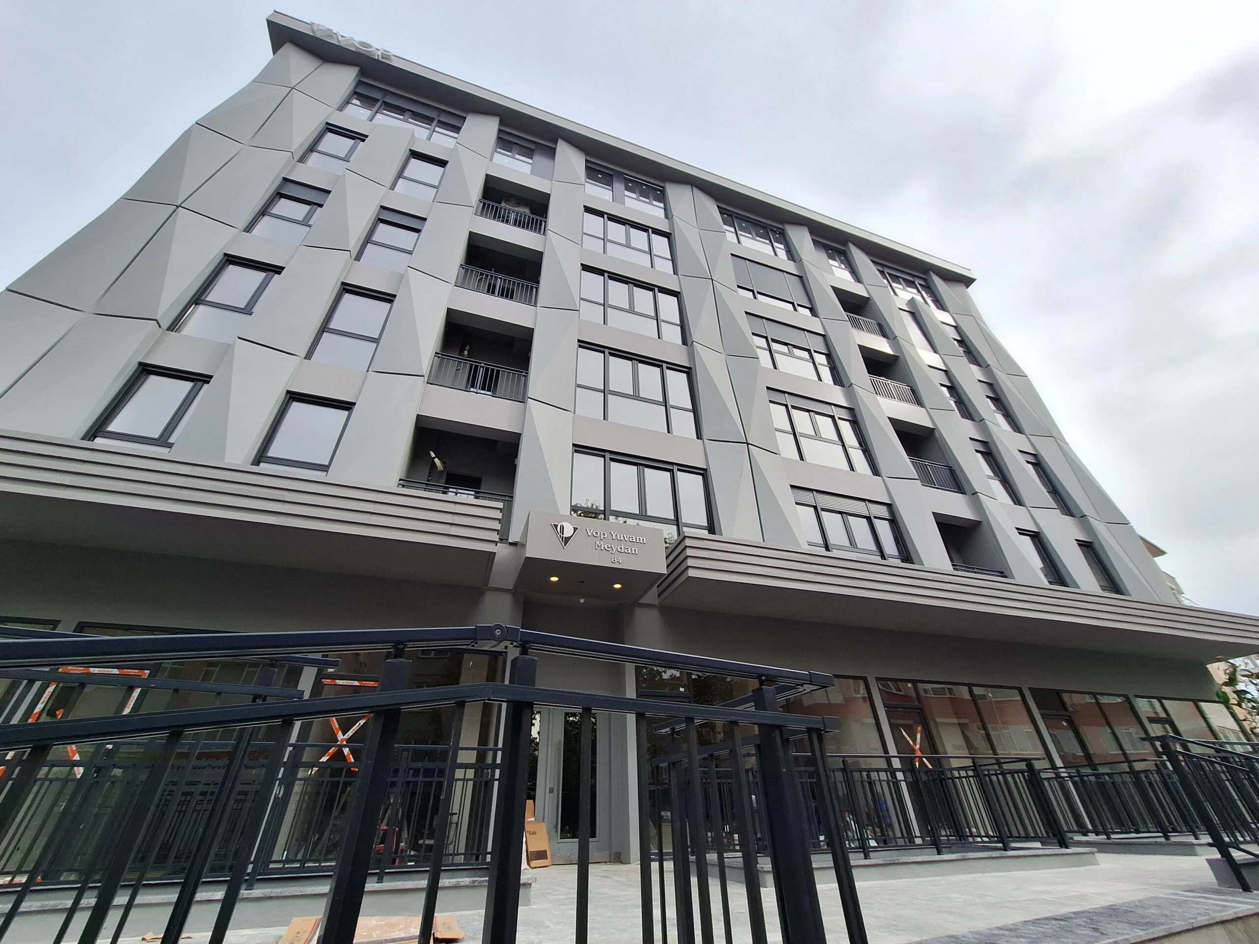 Apartment building in Besitkas - exterior view showing store front and six storey building