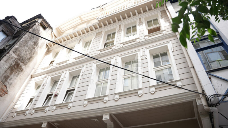 An exterior image of the facade of the building looking at the upper floors which extend up to four floors.