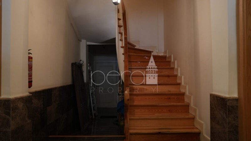 A view of the entree with its historic staircase made of wood.
